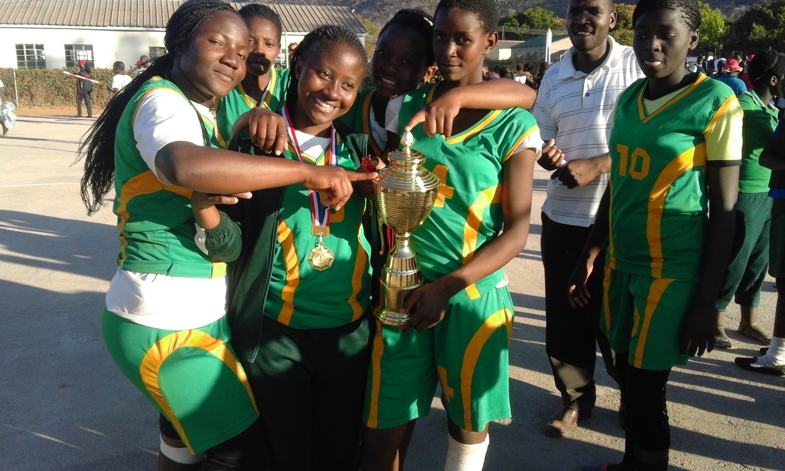 Students holding a trophy, celebrating as provincial champions.